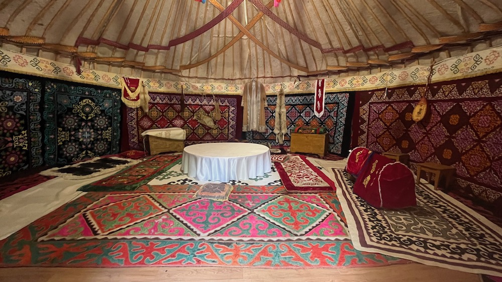 a yurt typical of kazakhstan's nomadic tribes, filled with rugs and pelts.