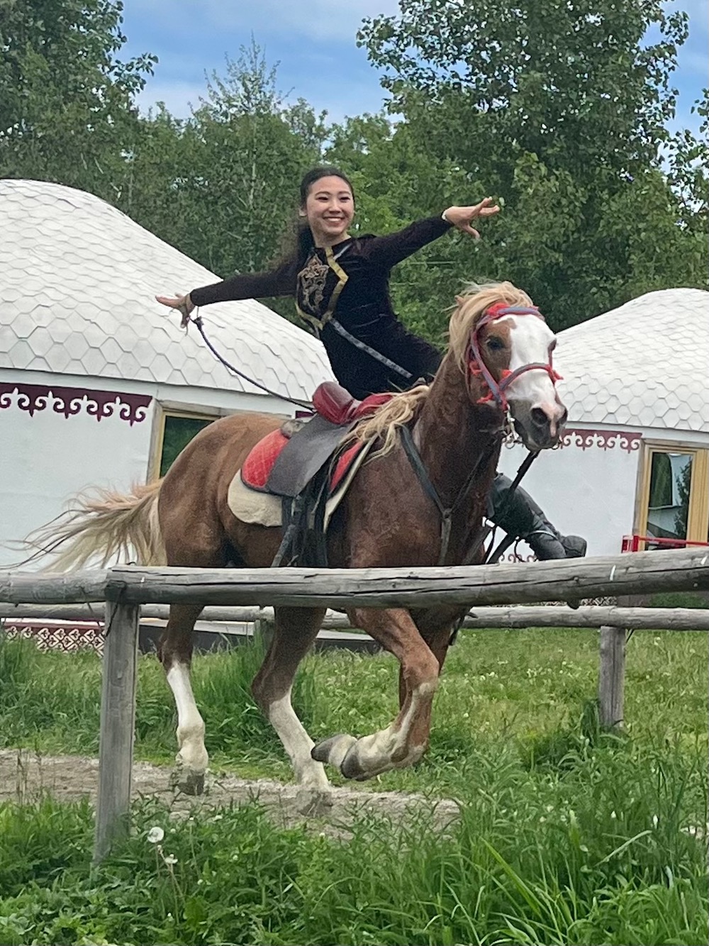 A woman balances sideways on a horse during a trick-riding demonstration at the huns ethno-village, outside of almaty.