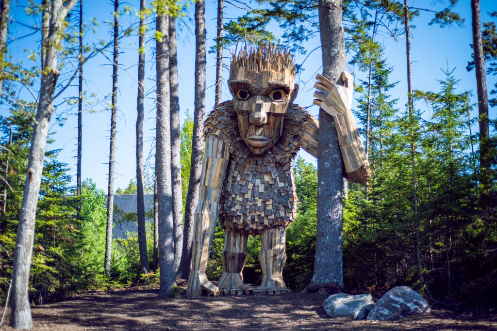 giant wooden trolls hide in the fall foliag and flowers at the coastal main botanical garden
