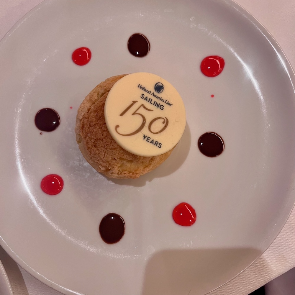 A disk of white chocolate on top of a dessert celebrates holland america's 150th anniversary.