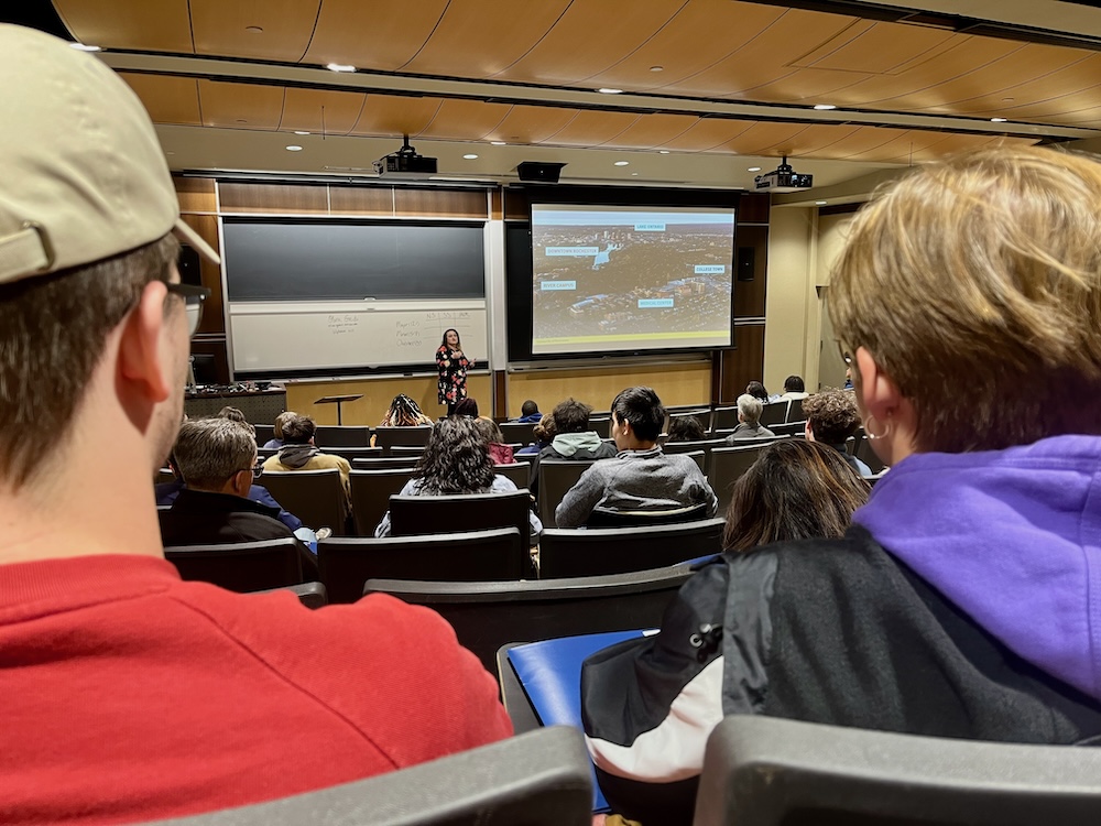 High schoolers and parents listen to an admissions counselor speak about the campus at the university of rochester.