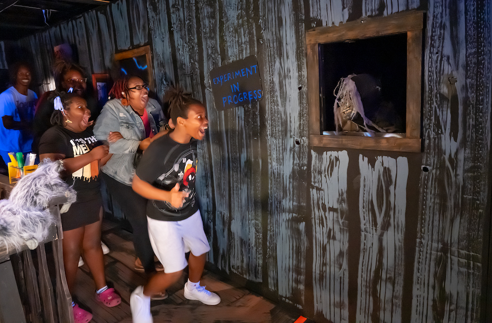 teens jump when a skeletal scientist jumps out at them during the indie children's museum booville haunted halloween event.