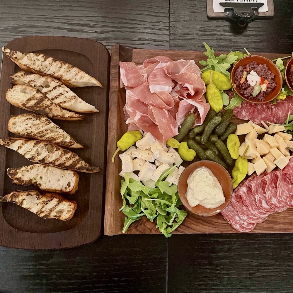 dia's charcuterie platter features local prosciutto and other meats and cheeses, alongside grilled local bread. 
