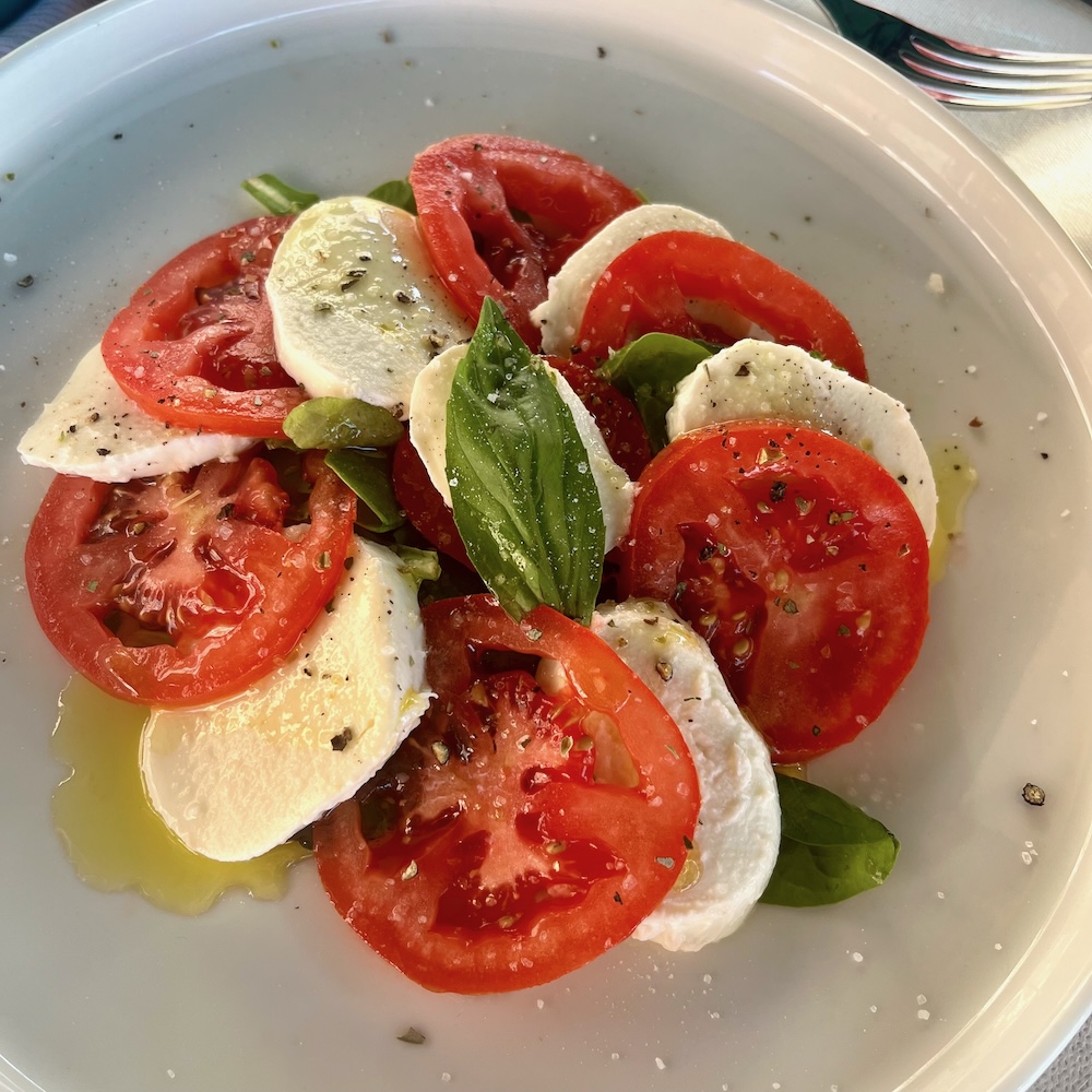 caprese salad with tomatoes, fresh mozzarella,basil, oregano and olive oil is a classic summer salad in italy