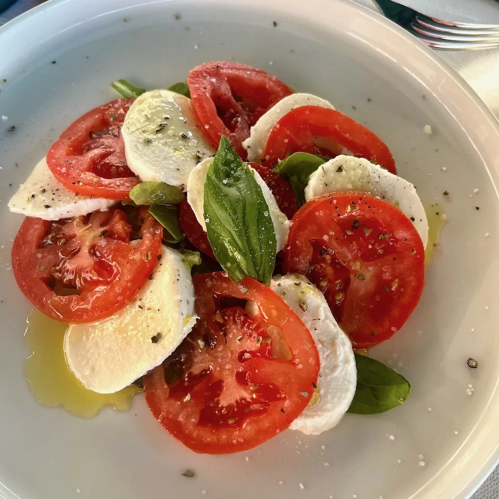 caprese salad with tomatoes, fresh mozzarella,basil, oregano and olive oil is a classic summer salad in italy