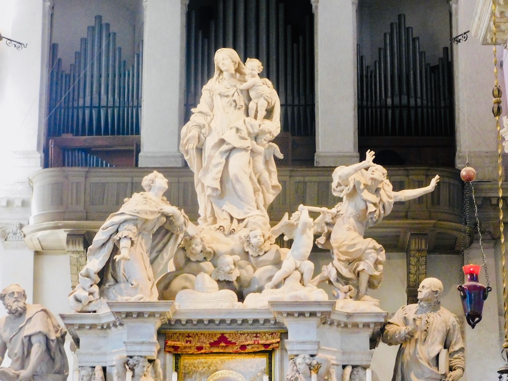 The large altar piece in venice's basilica of santa maria della slaute dramatically depicts mary dispelling the plague from venice
