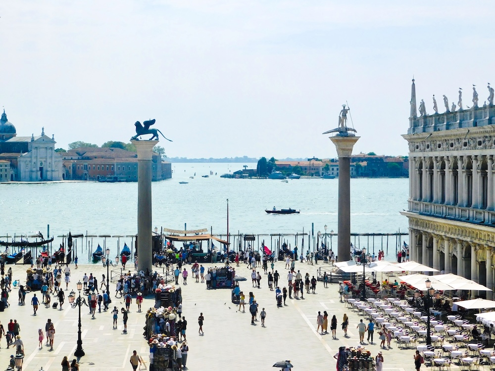 the two columns of a winged lion representing st. mark and of st. todaro are the unofficial gateway to venice, standing on the entrance to st. mark's square, near the lagoon docks.