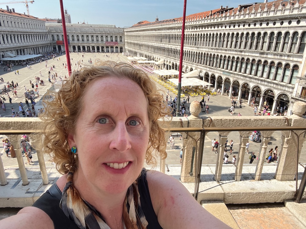 eileen from familiesgo! with the length of st, mark's square behind her from the loge of the basilica
