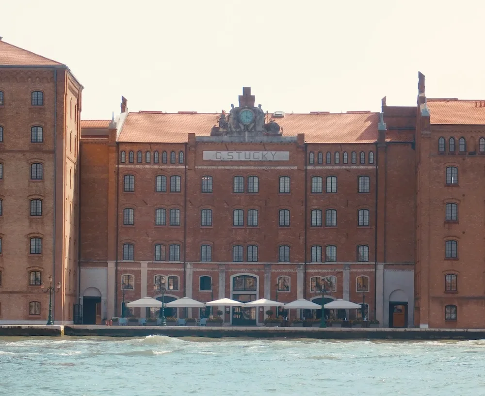 the stucky molino hilton hotel on giudecca in venice has an imposing facade and waterside patio.