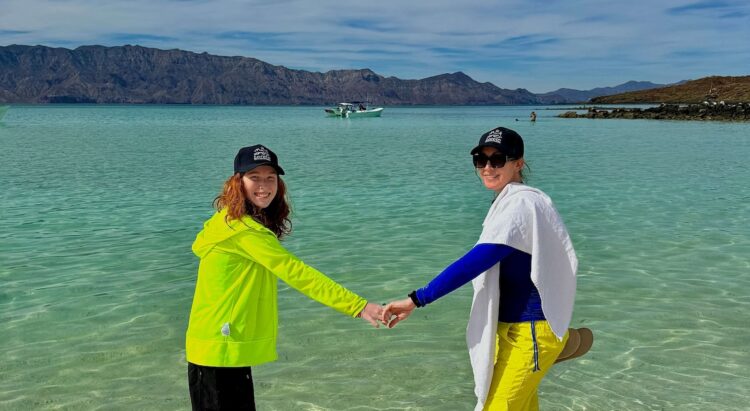 loreto, mexico: 10 adventurous things to do & see with kids: a mom and daughter head into the clear water off the shore of coronadao island near loreta, baja sur california