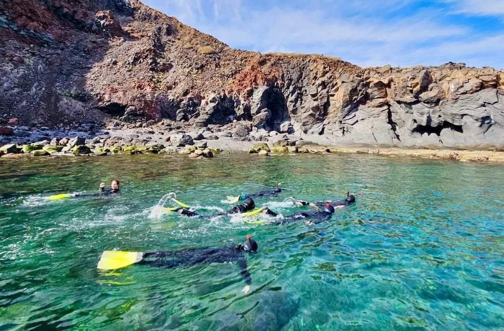 moms and daughters snorkel in the clear water off of isla coronados in baja sur california.
