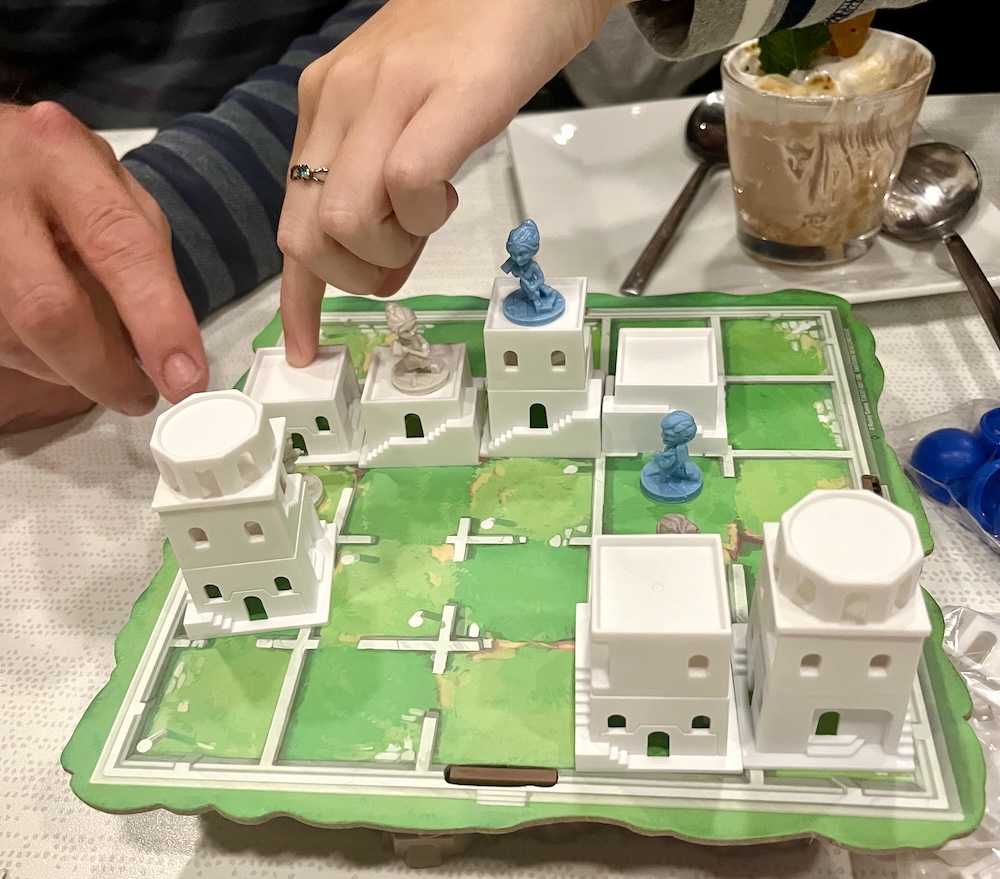 Two people discuss the moves in a board game at nervana cafe in rochester's neighborhoof of play.