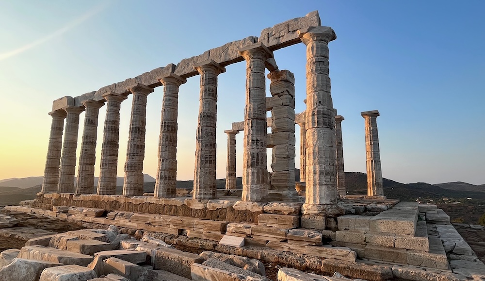the temple of poseidon sits atop a cliff, all by itself 40 miles from athens.