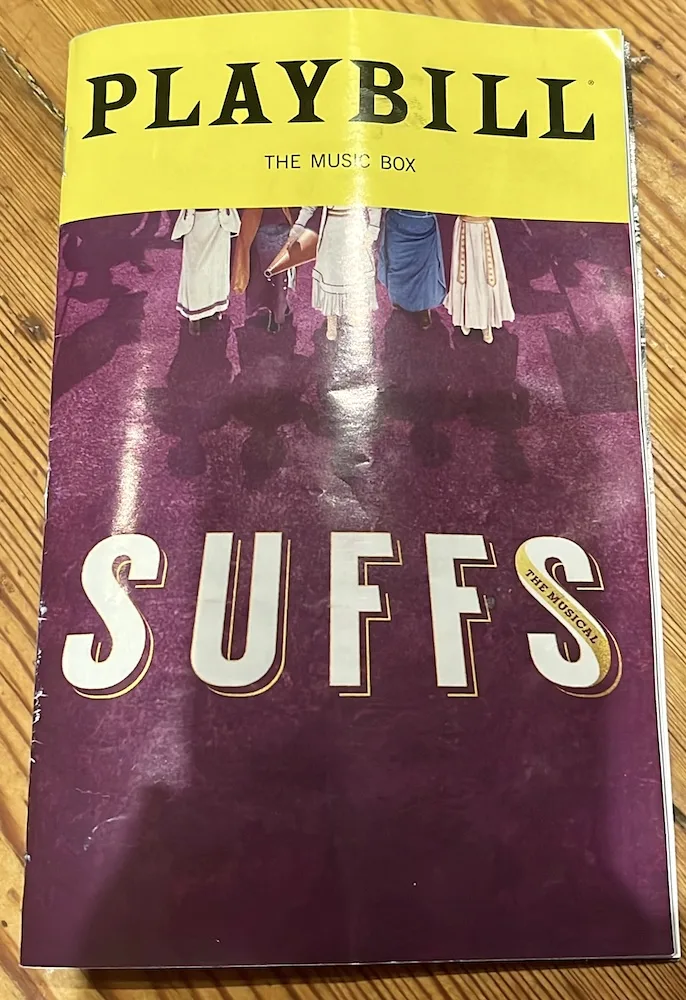 the playbill for the play suffs! showing women in early 20th centure clothes marching for their rights. 