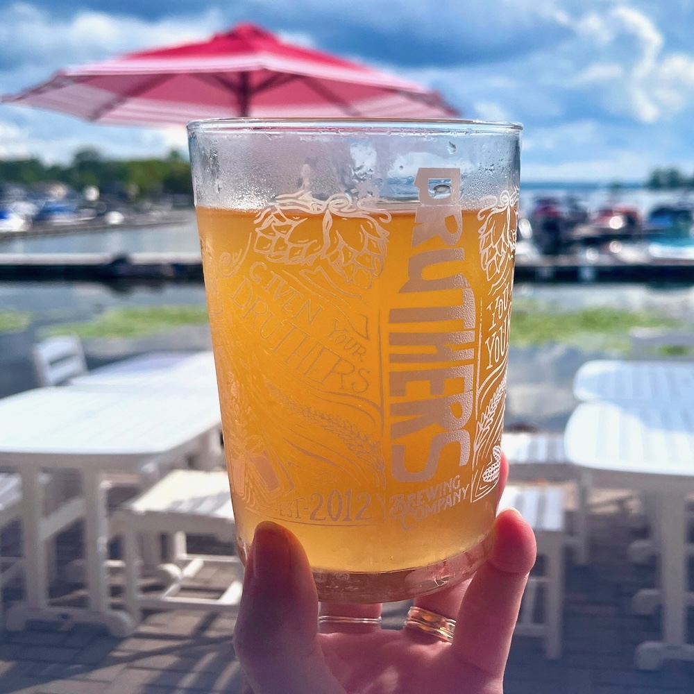 Druthers peach crush cider with saratoga lake in the background